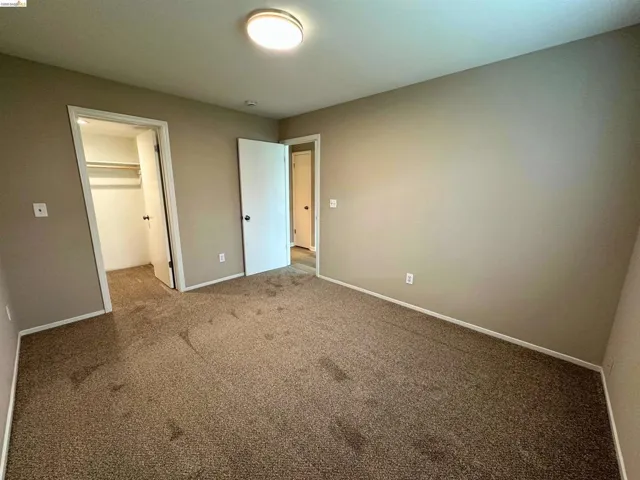 Unfurnished bedroom featuring a walk in closet and carpet floors