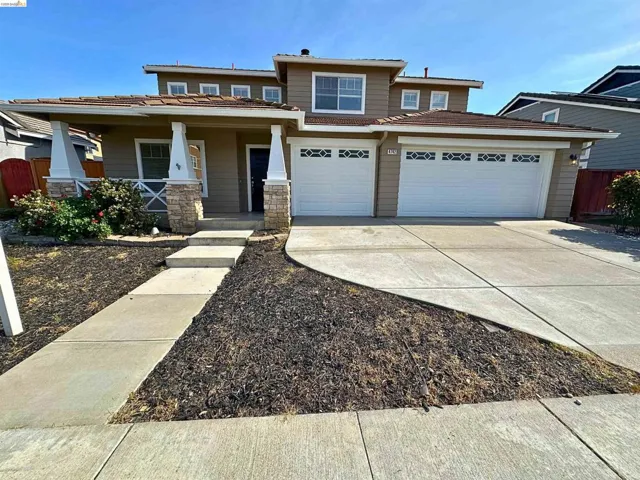 View of front of house with a porch, driveway, and a garage