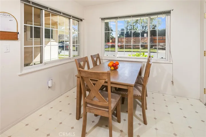 The adjoining dining room features two large windows, recessed lighting, and vinyl flooring, offering a comfortable space for both casual meals and gatherings.