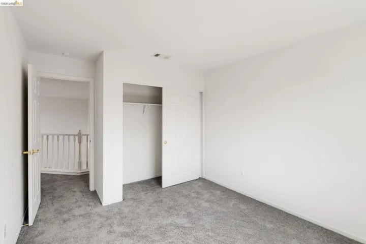 Unfurnished bedroom with light colored carpet and a closet