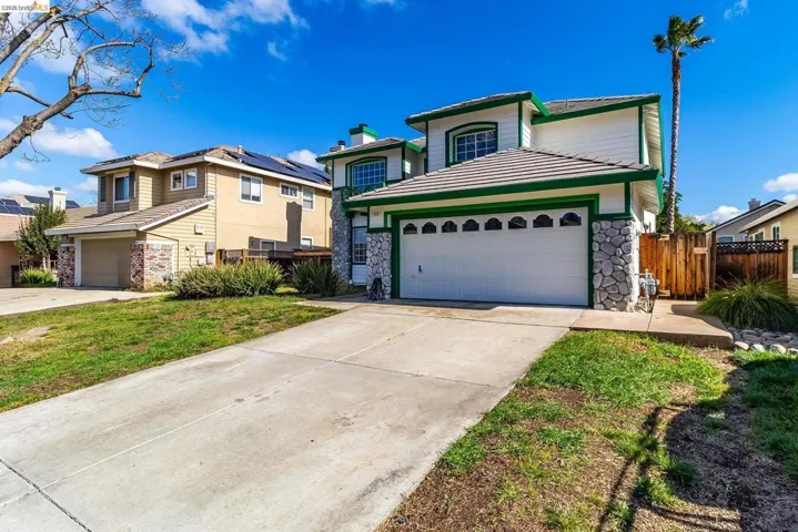 Traditional-style house with driveway and stone siding