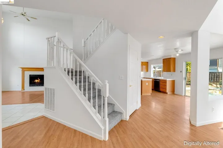 Staircase with a ceiling fan, a high end fireplace, wood finished floors, and recessed lighting