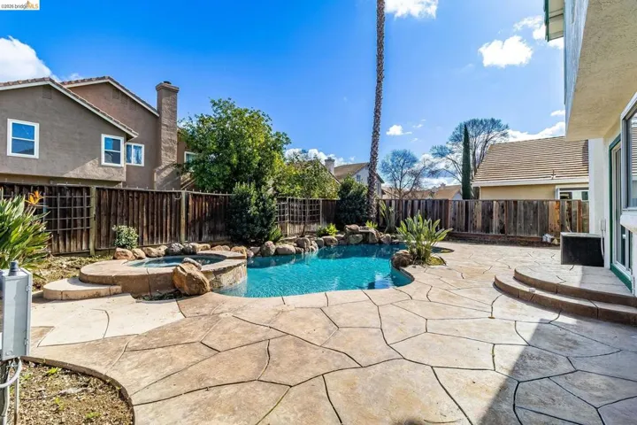 Integrated pool / spa featuring a patio area and a fenced backyard