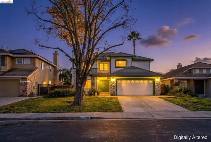 Traditional home featuring stone siding, concrete driveway, and an attached garage