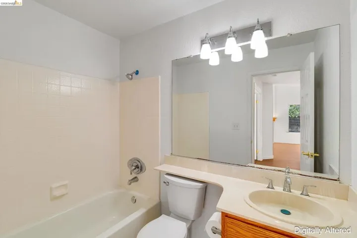 Full bath featuring vanity, bathtub / shower combination, and a textured wall