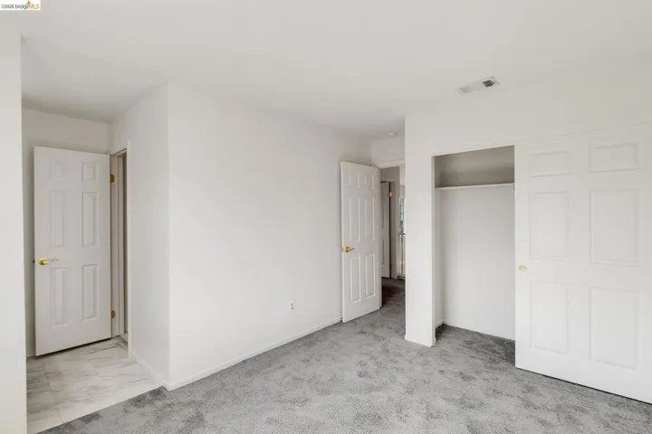 Unfurnished bedroom with light colored carpet and a closet