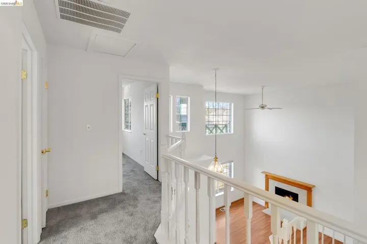 Hallway with an upstairs landing and a chandelier