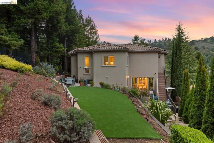 Rear view of property featuring a patio area, a lawn, stucco siding, and a tiled roof