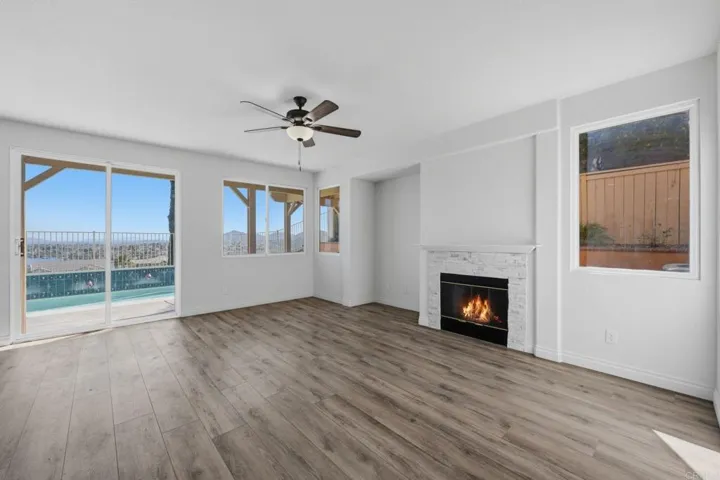 Open concept kitchen/den which looks onto patio, pool and lake views with cozy fireplace