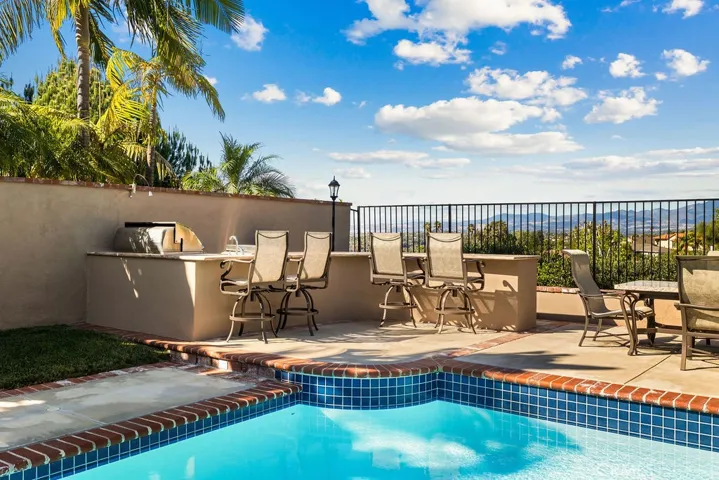 Outdoor entertaining area with large grill, refrigerator, cooktop, and sink