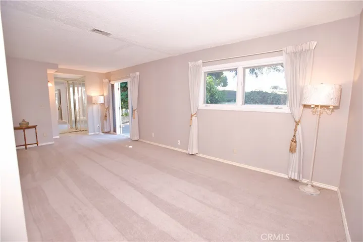 Primary bedroom with window view and French door leading to the backyard