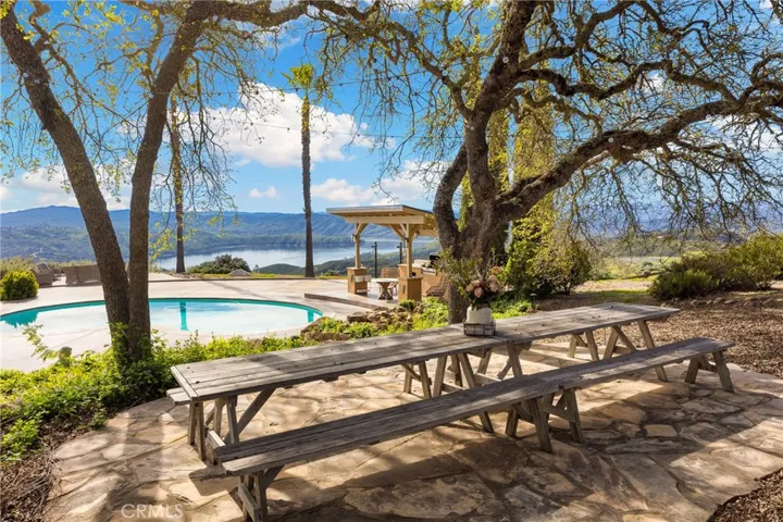 Private gathering space under mature oaks overlooking the pool and lake