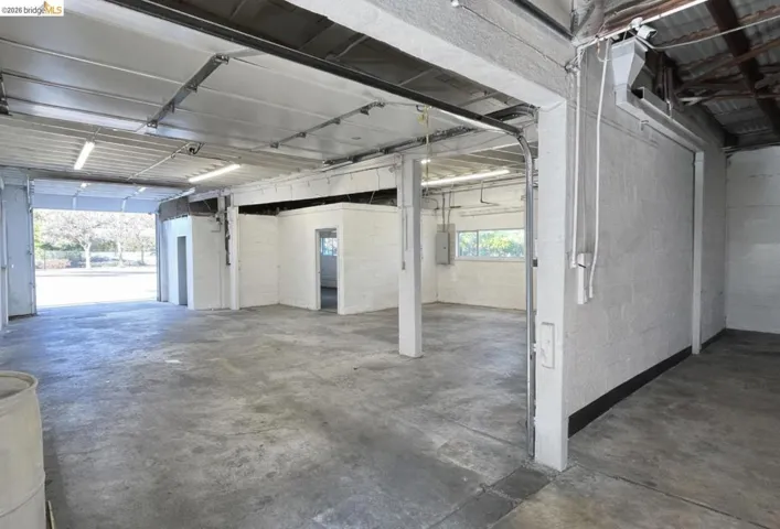 Garage featuring concrete block wall and electric panel