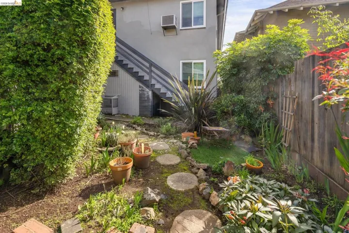 View of yard featuring stairway and a wall unit AC