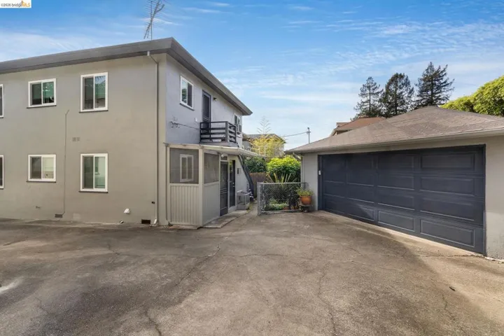 View of property exterior with a balcony, an outbuilding, a garage, and stucco siding