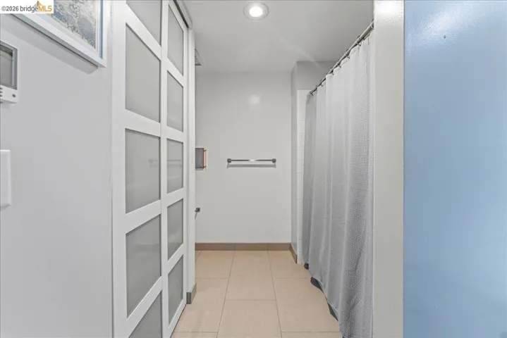 Corridor with light tile patterned floors and recessed lighting