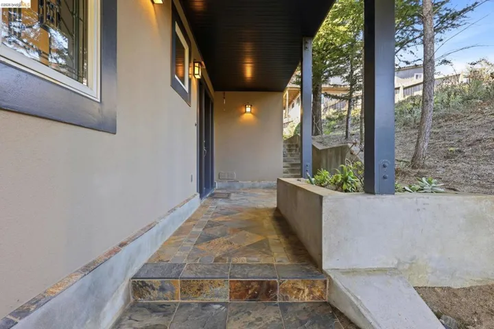 View of exterior entry featuring covered porch and stucco siding