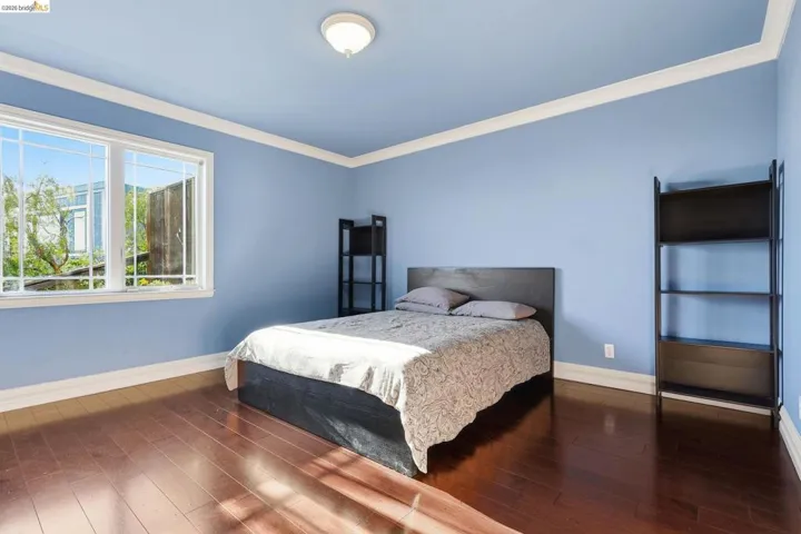 Bedroom featuring hardwood / wood-style floors and crown molding