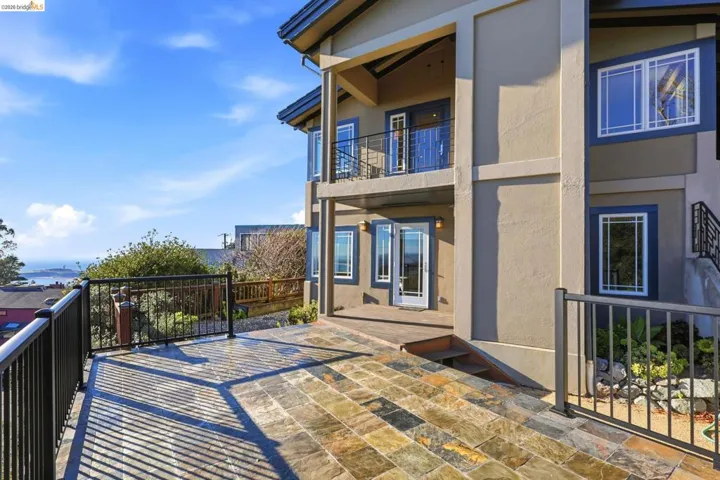 Rear view of property with stucco siding and a balcony