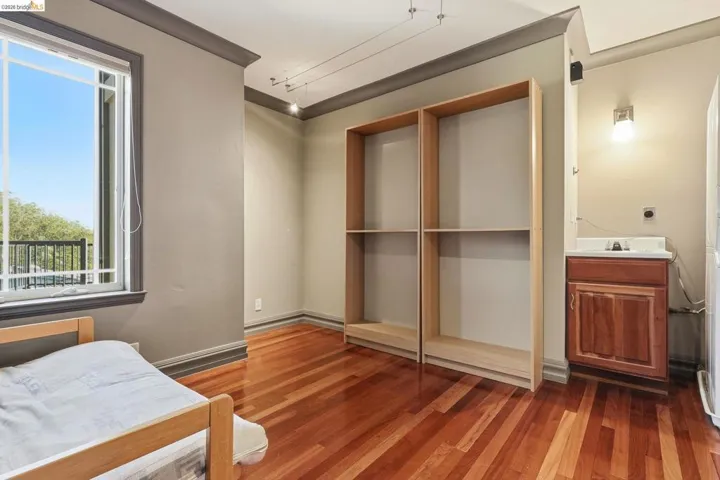 Bedroom with dark wood-style flooring and crown molding