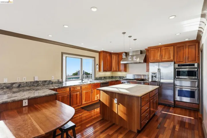 Kitchen with a breakfast bar, stainless steel appliances, and wood finish cabinets
