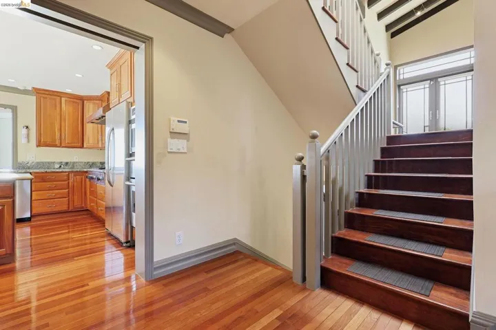 Staircase with hardwood / wood-style flooring and baseboards
