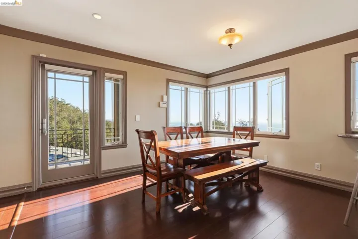 Dining space featuring dark wood-style flooring and ornamental molding