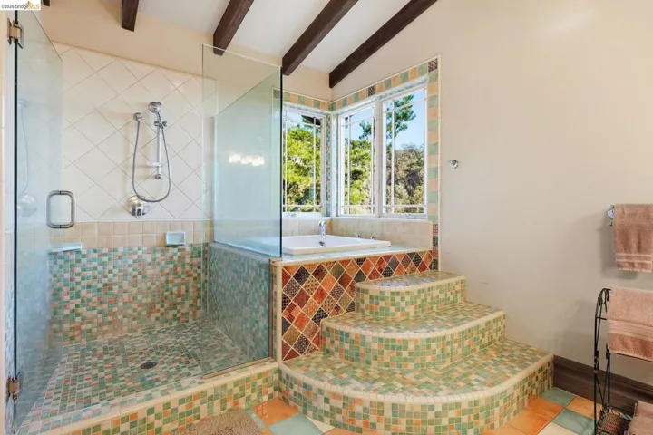 Bathroom with a garden tub, a shower stall, tile patterned flooring, and lofted ceiling with beams