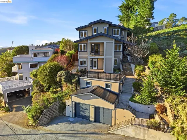 View of front of home with a balcony, stucco siding, and driveway