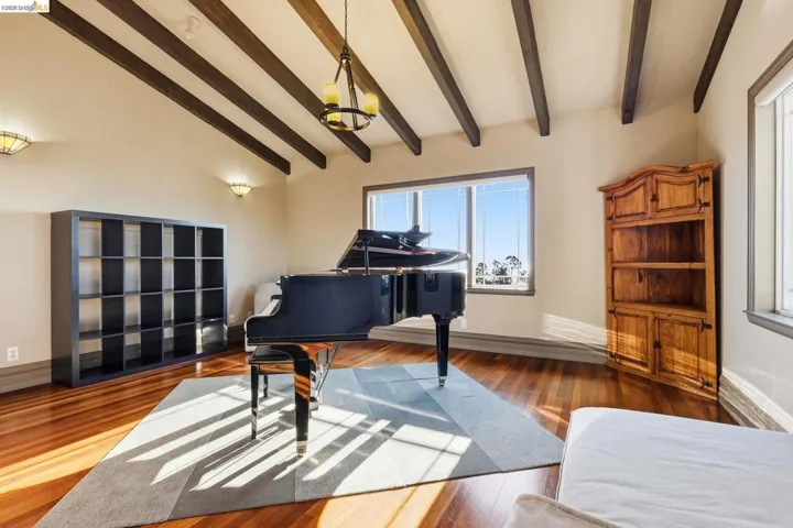 Living area with wood finished floors and vaulted ceiling with beams