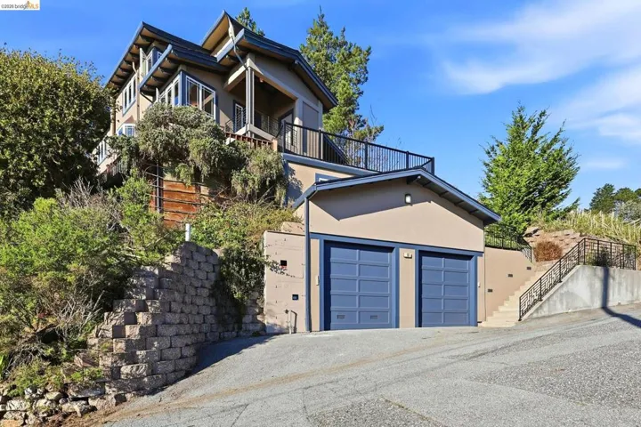 View of front of home with stucco siding, a balcony, and a garage
