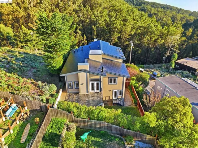 Aerial view of property and surrounding area with a heavily wooded area
