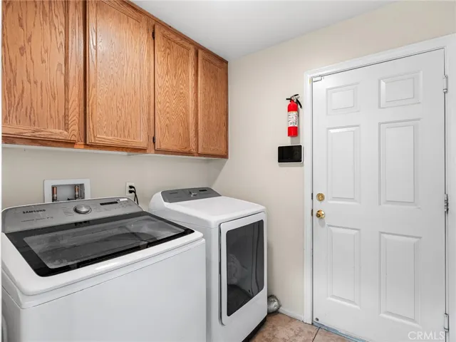 Convenient indoor laundry area with tile flooring and direct access to the attached two-car garage. Designed for everyday functionality and efficiency, keeping laundry comfortably inside the home.