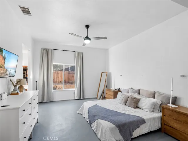 Spacious primary suite featuring high ceilings, abundant natural light, and plenty of room for a full bedroom set. The layout offers privacy from secondary bedrooms, creating a comfortable retreat at the end of the day.