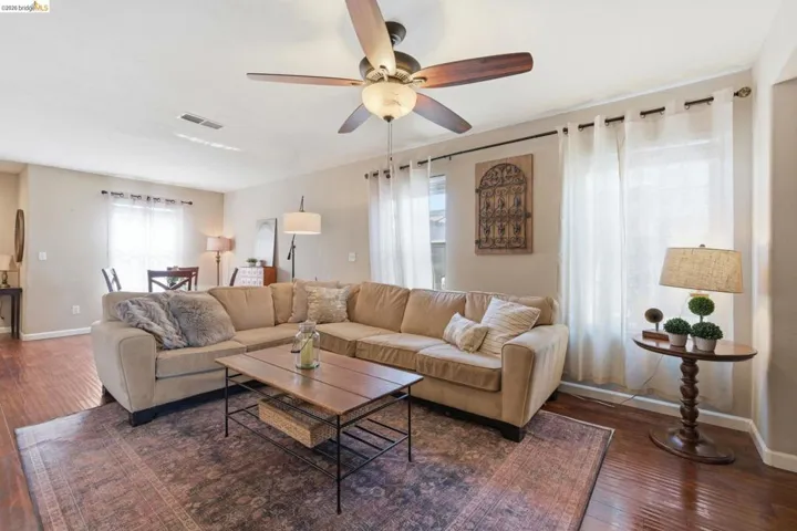 Living room featuring ceiling fan and hardwood / wood-style flooring