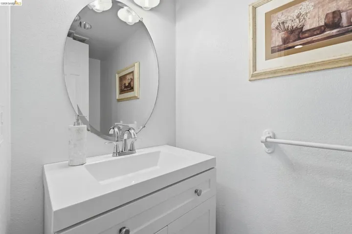First level bathroom with vanity and a textured wall
