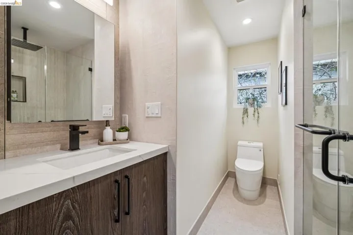 Bathroom featuring a stall shower, vanity, recessed lighting, and tasteful backsplash