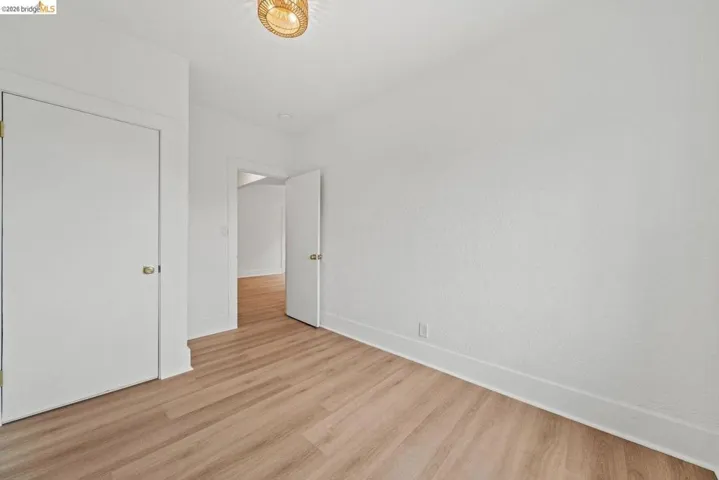 unfurnished bedroom featuring wood finished floors and baseboards