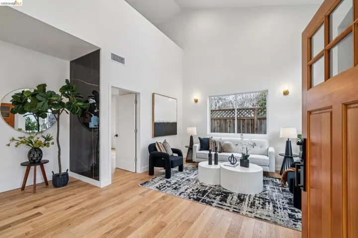 Living room featuring a high ceiling and light wood finished floors