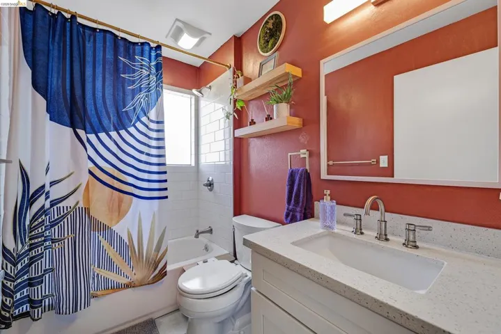 Bathroom featuring vanity and shower / bathtub combination with curtain