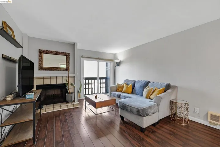Living area with a tile fireplace and hardwood / wood-style flooring