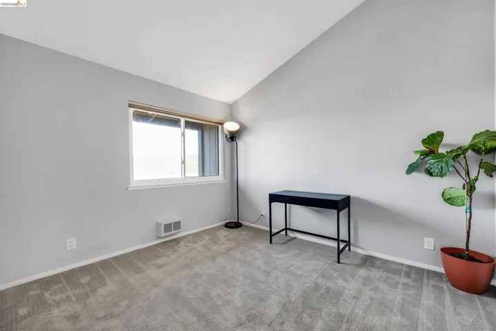 Unfurnished room with lofted ceiling and light colored carpet