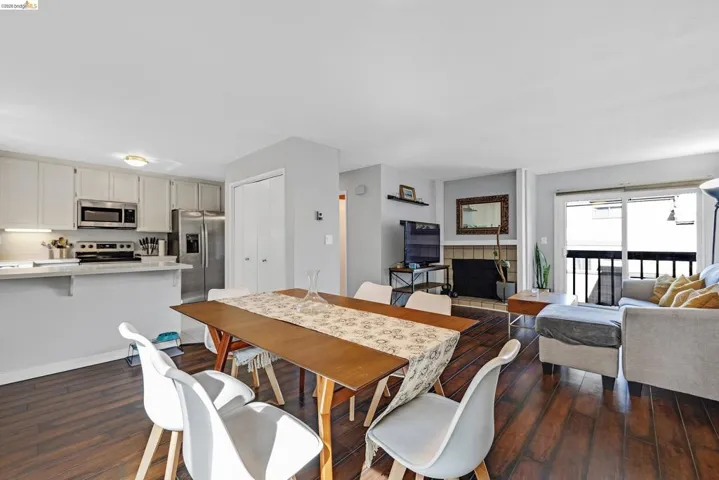 Dining space with dark wood-style floors and a tile fireplace