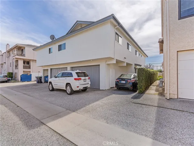 Backside of building, showing 2 shared 2-car garages and driveway
