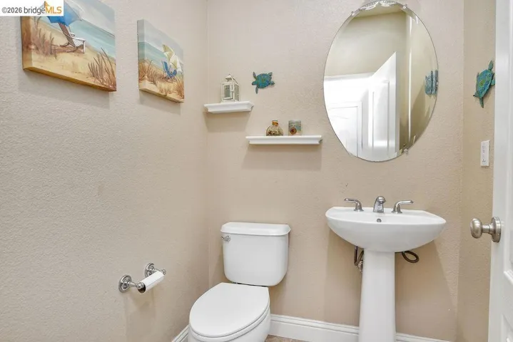 Bathroom featuring toilet and a textured wall