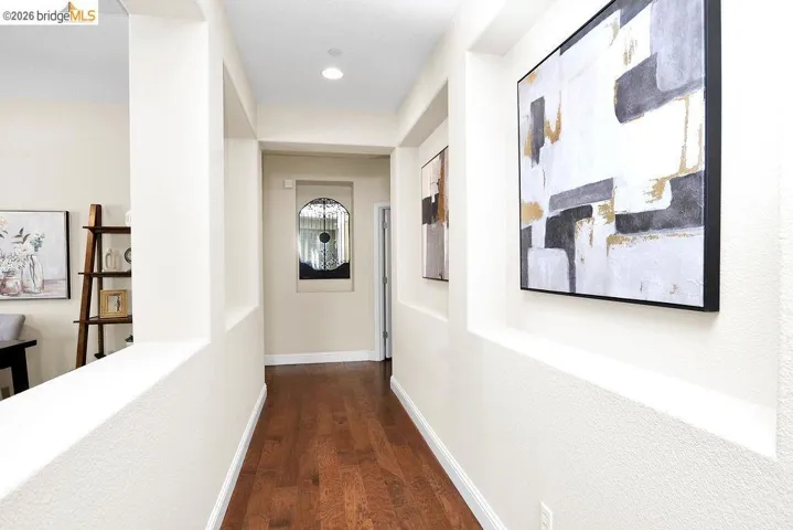 Hall featuring dark wood-type flooring and baseboards