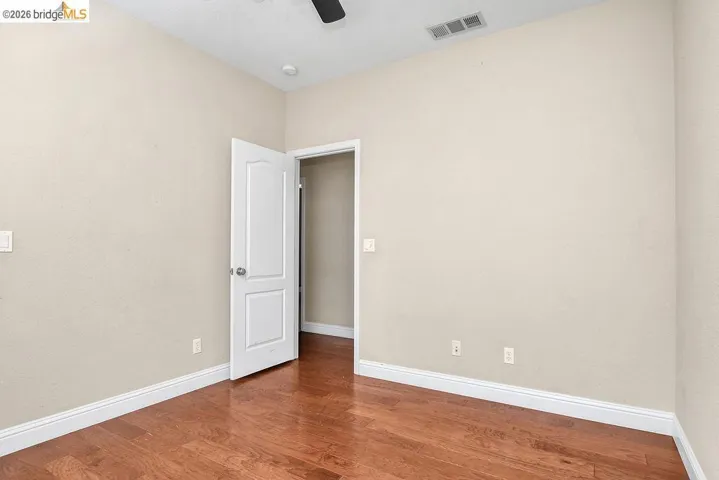 Empty room featuring wood finished floors and a ceiling fan