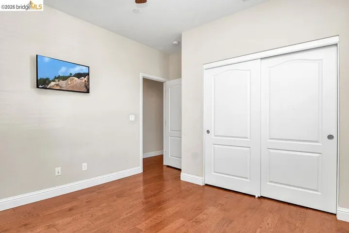 Unfurnished bedroom with wood finished floors and a closet