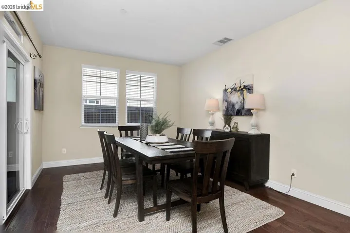 Dining space featuring baseboards and dark wood-style flooring