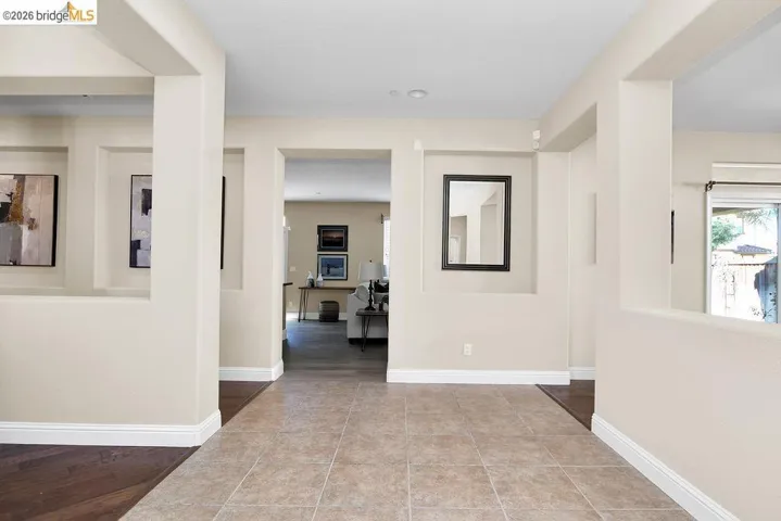 Hallway featuring light tile patterned floors and baseboards